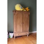 A PINE TWO DOOR WARDROBE with acanthus s