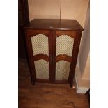 AN OAK CABINET with brass grilled doors