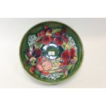 A MID 20TH CENTURY MOORCROFT GREEN GLAZED SHALLOW BOWL decorated in the orchid pattern, W.