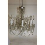 AN EARLY 20TH CENTURY FRENCH EIGHT LIGHT CRYSTAL CHANDELIER with eight shepherds crook arms