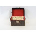 AN EARLY 20TH CENTURY BONE AND BAMBOO MAH JONG SET in original leather carrying case,