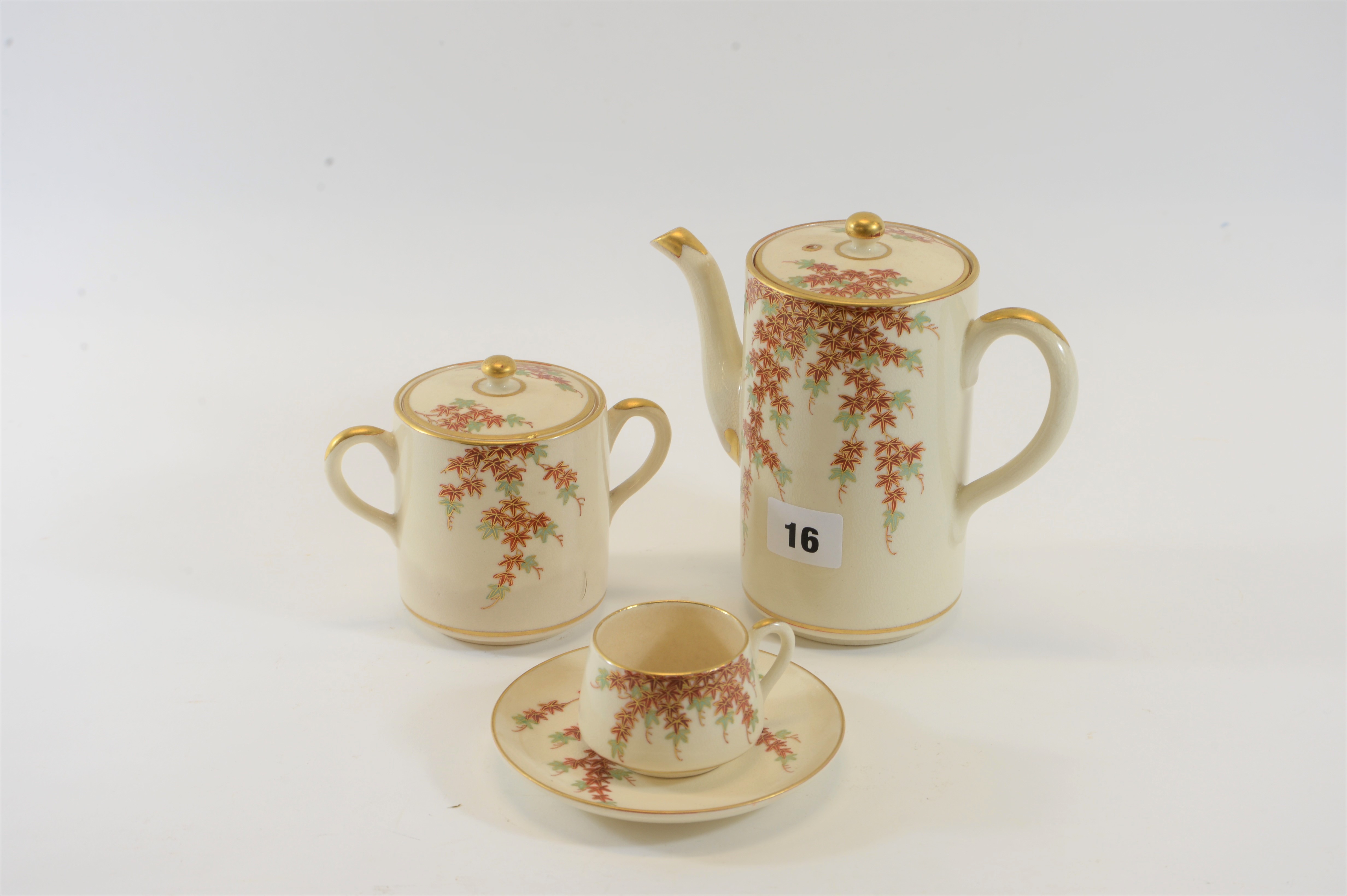 AN EARLY 20TH CENTURY SATSUMA POTTERY FIFTEEN PIECE COFFEE SERVICE decorated with foliage.