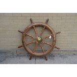 A LATE 19TH/EARLY 20TH CENTURY TEAK EIGHT-SPOKE SHIPS WHEEL with brass centre boss,