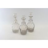 A SET OF THREE 19TH CENTURY CUT GLASS DECANTERS with star cut mushroom stoppers,