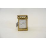 AN EARLY 20TH CENTURY BRASS 8 DAY CARRIAGE CLOCK with white enamel dial, 4 1/4 ins high.