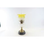 A LATE VICTORIAN TABLE OIL LAMP with clear glass fount, brass base and pottery plinth,