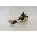 A LATE 19TH/EARLY 20TH CENTURY CAST-IRON HORSE DRAWN CART with driver up, probably American,