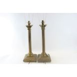 A PAIR OF REPRODUCTION BRASS CORINTHIAN COLUMN TABLE LAMPS raised on square foliate chamfered edge