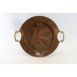 AN EARLY 20TH CENTURY CIRCULAR ARTS AND CRAFTS INFLUENCE COPPER TRAY with leaf and berry decoration