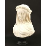 A Continental composite marble bust depicting veiled lady on turned base.