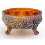 Carnival Glass: An orange Carnival glass three footed bowl with rose decoration 7 1/2" diameter