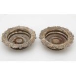 A pair of silver plate bottle coasters with turned wooden bases Each 8" diameter overall