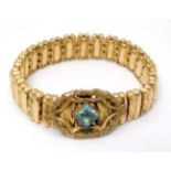 A gold plated expanding bracelet with aqua blue stone decoration marked Pat 1905.