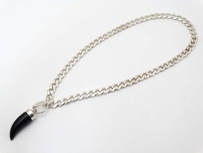 A silver flat cublink chain with black onyx like pendant.