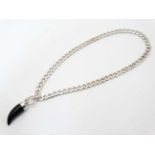 A silver flat cublink chain with black onyx like pendant.