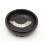 A turned ebony pin dish with silver mount to centre hallmarked London 1921.