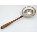 A silver strainer with turned wooden handle. Hallmarked Israel Freeman & Son Ltd.