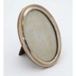 A silver photograph frame of oval form hallmarked Birmingham 1921 maker Henry Matthews.