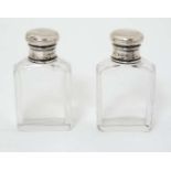 A pair of glass bottle with silver tops hallmarked London 1924 maker A&C? 2 3/4" high