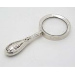 A magnifying glass with silver surround hallmarked Birmingham 1979 maker S J Rose & Son.