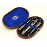 A necessaire / cased sewing set containing various items, some silver handled and a silver thimble .