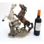 A modern resin polychrome sculpture of two rearing horses , signed B Auzot. 15'' high.