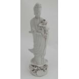 A Chinese Blanc de Chine figure of Guanyin, holding a lotus flower on pedestal base,