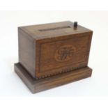 A 1920's oak table top cigarette dispenser with inlaid and checkered decoration.