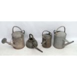 Salvage : a Garden and Architecture a collection of 4 galvanized watering cans of various sizes,