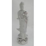 A Chinese Blanc de Chine figure of Guanyin, holding a lotus flower on pedestal base,