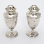 A matched pair of silver pepperettes hallmarked London 1904 maker William Comyns Son.