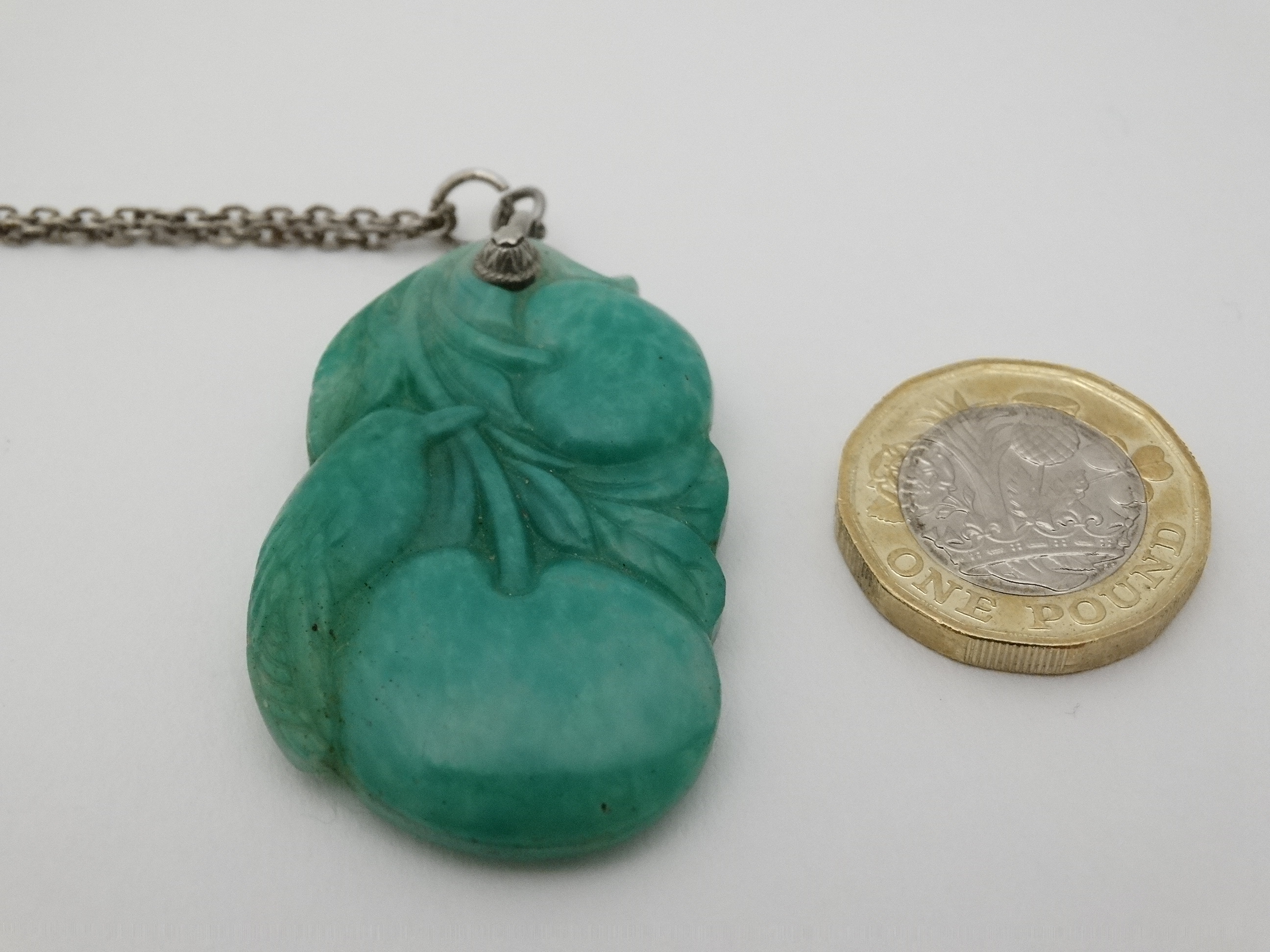 A carved green jade pendant depicting a bird with fruit 1 3/4" long CONDITION: