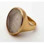 A yellow metal gold signet ring set with family crest intaglio chalcedony seal to top.
