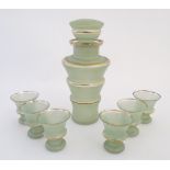 A retro pale green glass decanter and stopper of tapering from with gilt banded detail together