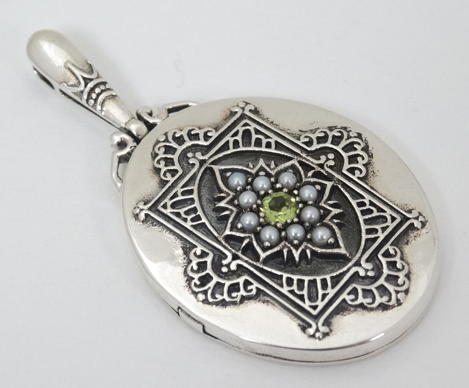 A white metal pendant locket set with central peridot 2" long CONDITION: Please