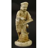 An Japanese ivory Meiji okimono formed as a figure trading and holding an abacus. Signed under.