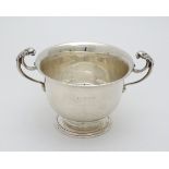 A silver bowl with twin handles having stylised lion decoration.