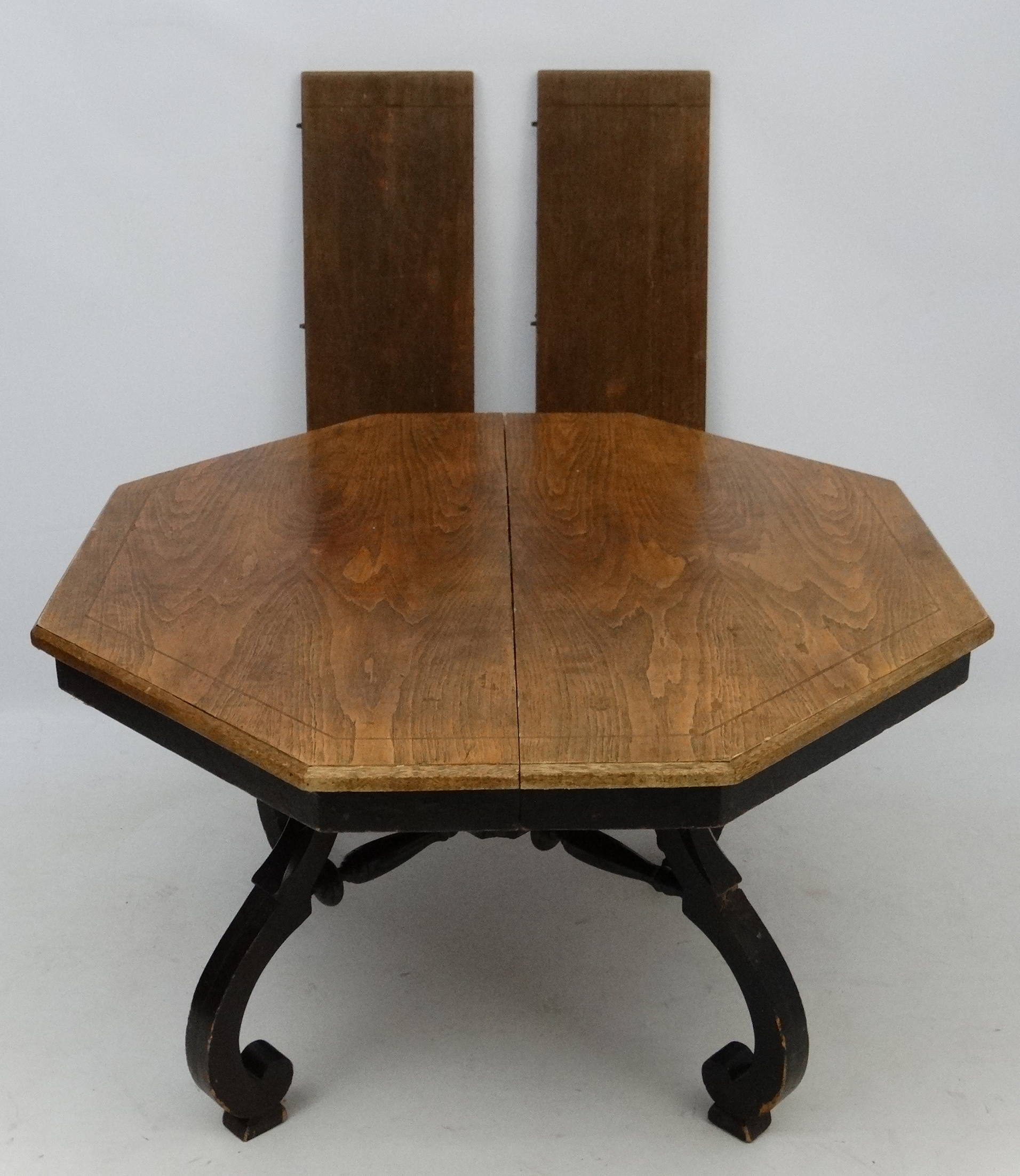 An early 20thC American octagonal oak topped four legged centre table with ebonised base,