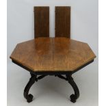An early 20thC American octagonal oak topped four legged centre table with ebonised base,