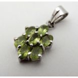 A silver pendant set with pale green stones.