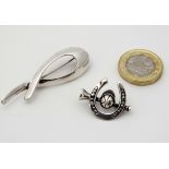 A silver brooch of abstract form together with a brooch formed as a hunting horn with horseshoe and
