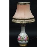 A Victorian hand painted ceramic bottle shaped table lamp with rose decoration.