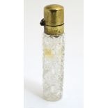 A late Victorian brass topped glass scent bottle with hobnail like cut decoration.