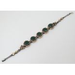 A silver bracelet set with green and white stones with gilt decoration CONDITION: