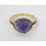 A silver gilt ring set with purple stone bordered by white stones CONDITION: Please