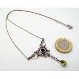 A silver necklace with pendant set with amethyst peridot and seed pearls.