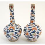 A pair of Chinese blue and white bottle vases decorated with lucky symbols in orange ,