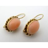 A pair of 18ct gold earrings set with coral cabochon .