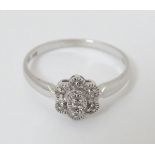 A 14k white gold ring set with diamonds in a daisy setting CONDITION: Please Note