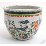 A Chinese Famille Verte jardiniere decorated with exotic birds and insects amidst flowering boughs,